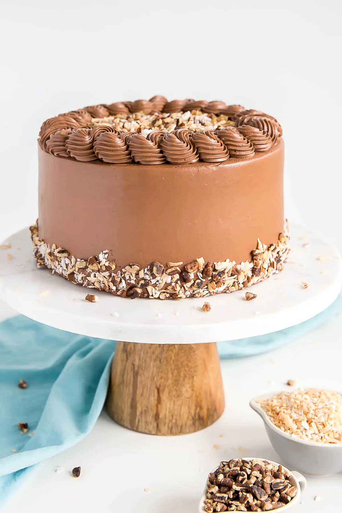 Profile shot of the cake with chocolate buttercream and chopped pecans along the bototm.