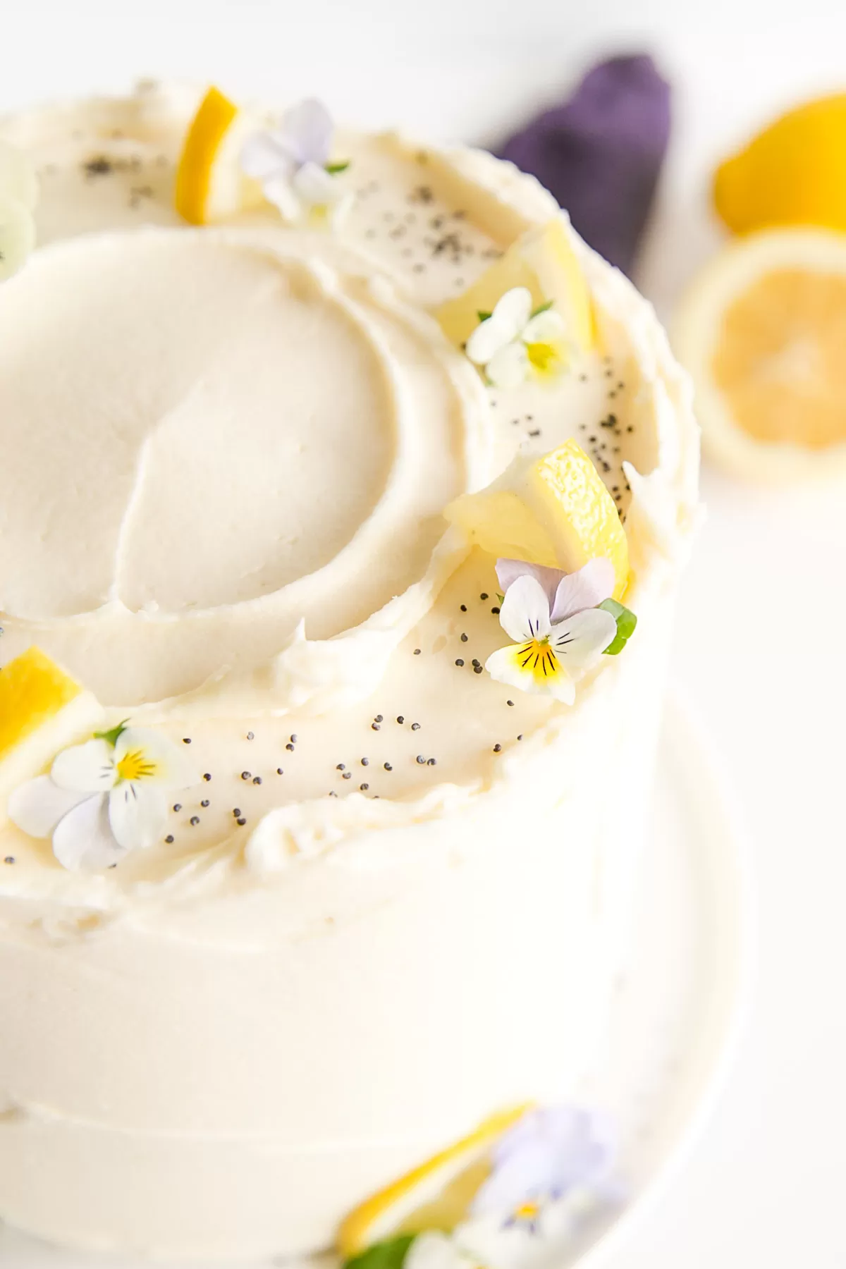 Close up of the lemon slices and pansies on the top of the cake.