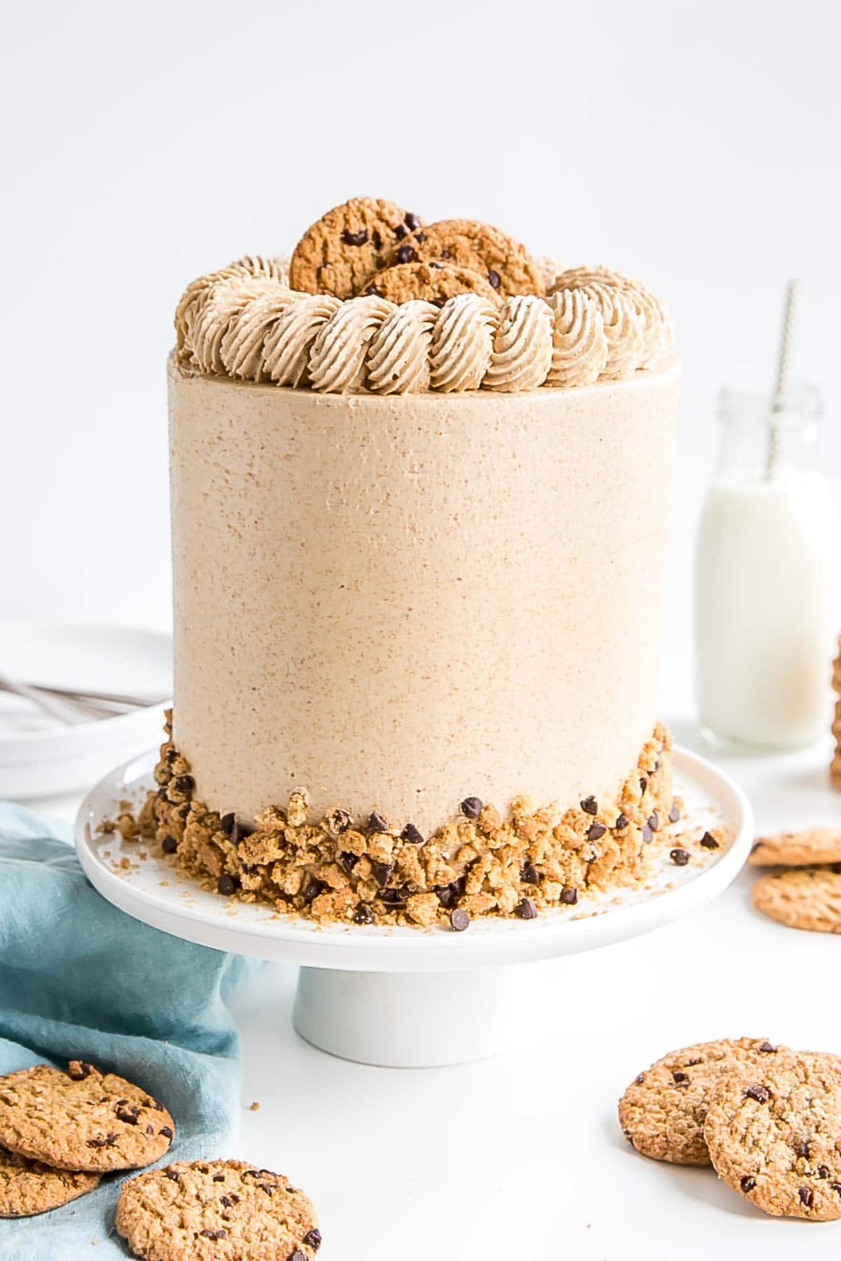 Cake on a white cake stand with a blue cloth in the background.. 