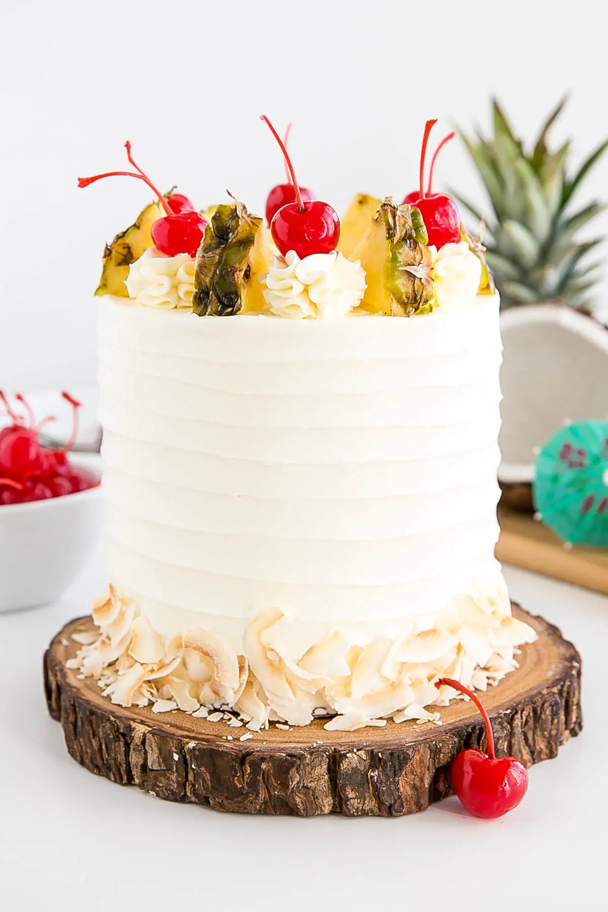 White cake with rustic frosting on a wood cake plate.