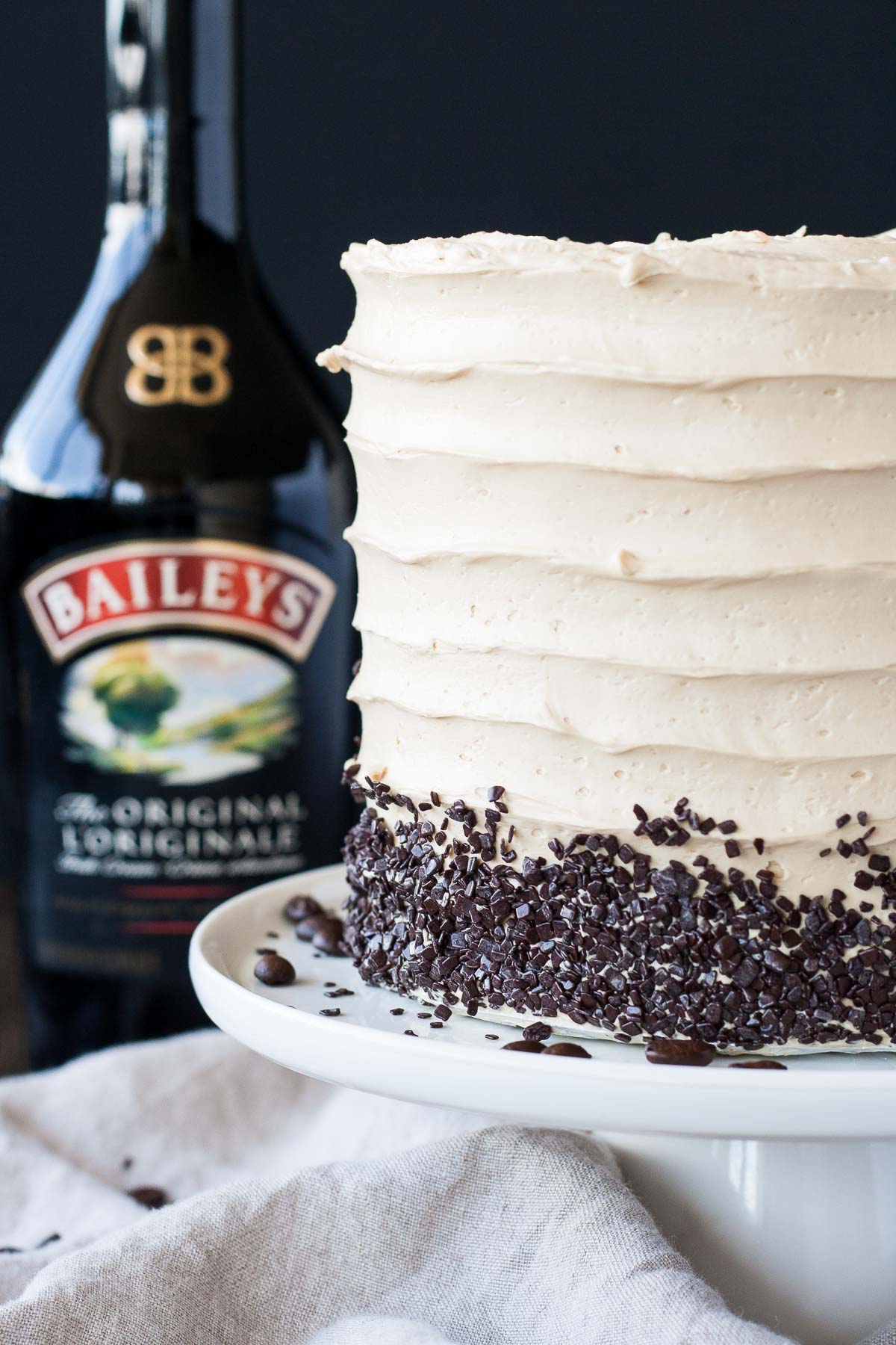 Close up of the side of the cake with a bottle on Baileys behind it.