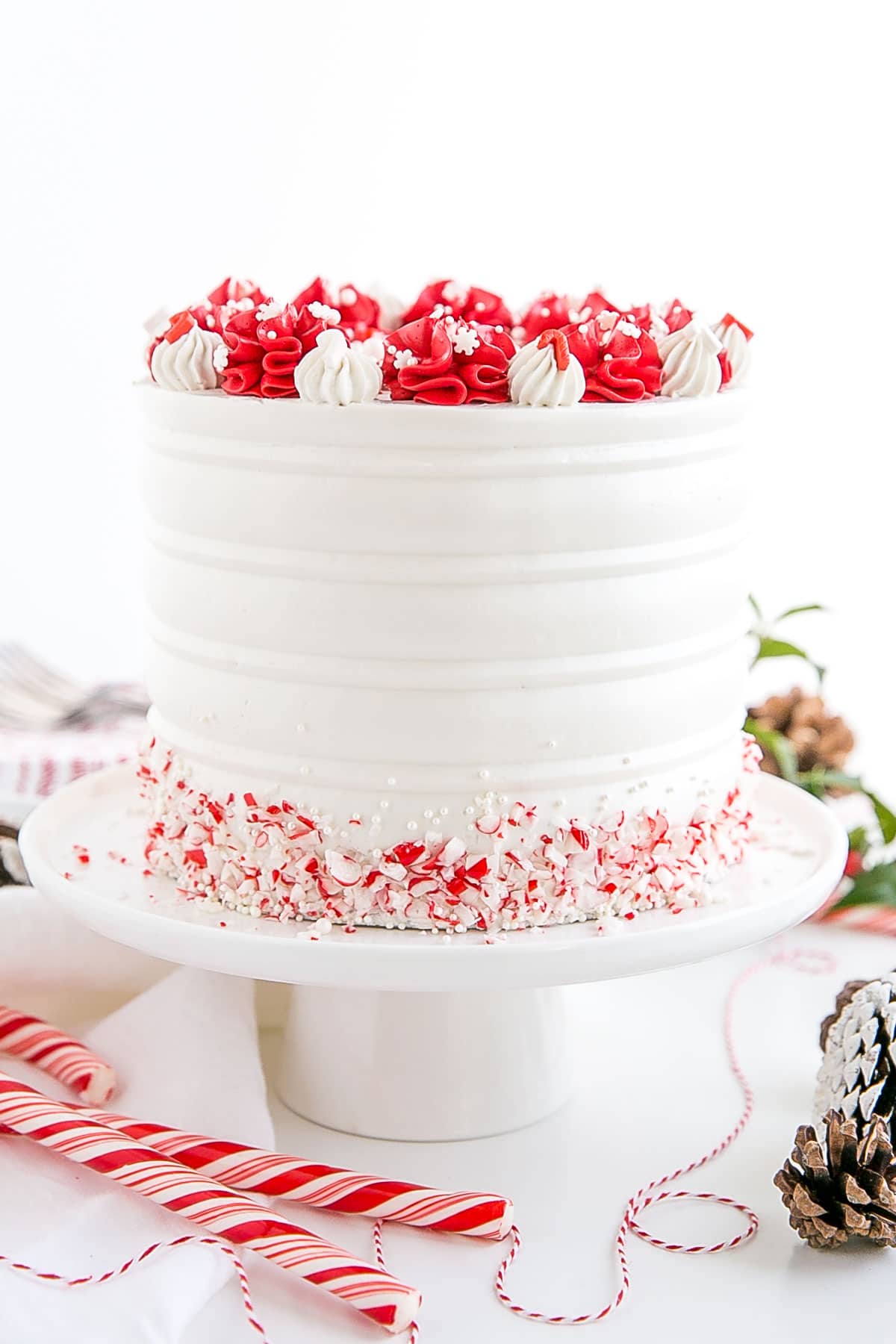 Red and white cake on a white cake stand.