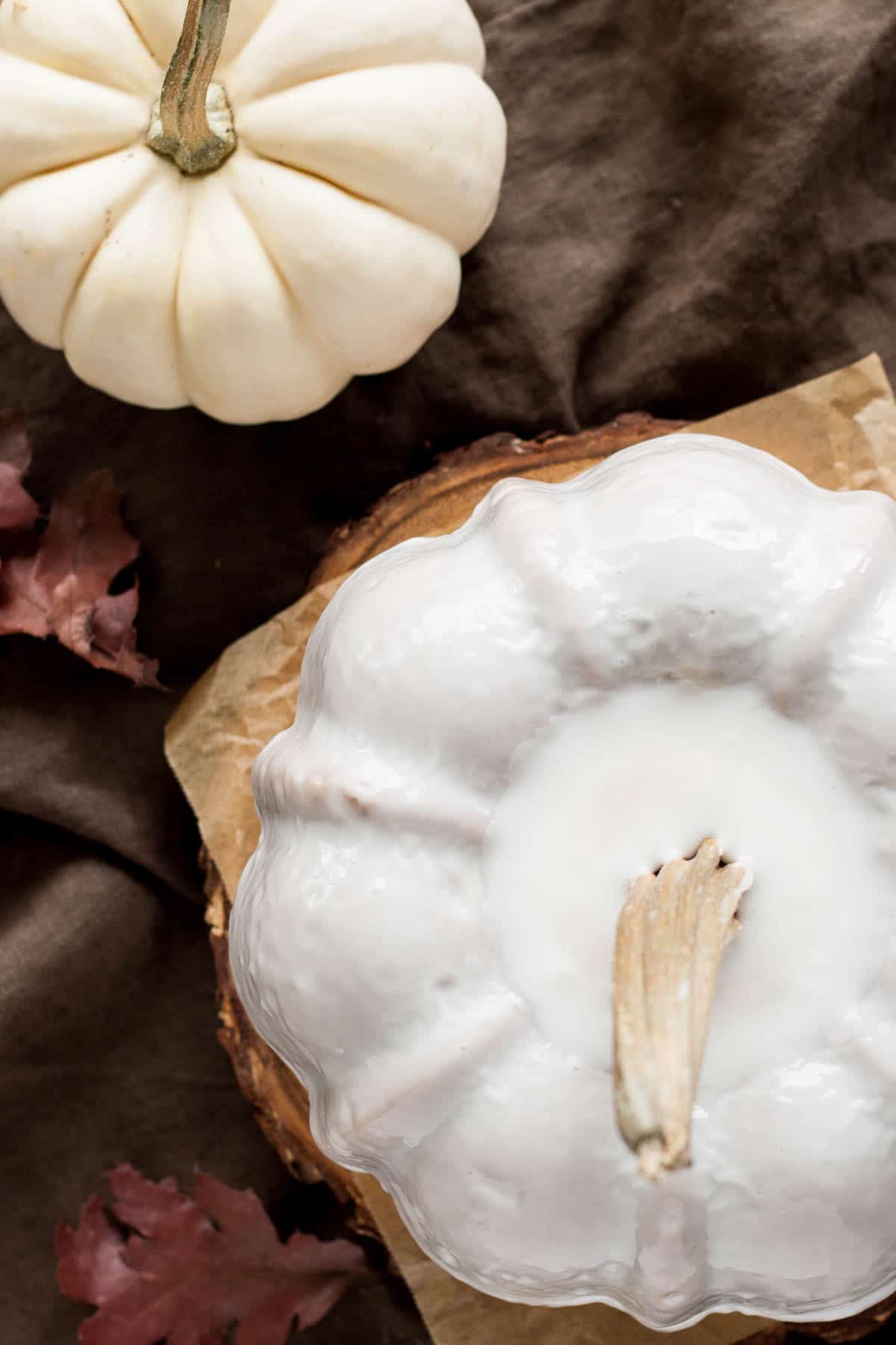 Overhead shot of the pumpkin Bundt with a white pumpkin beside it.