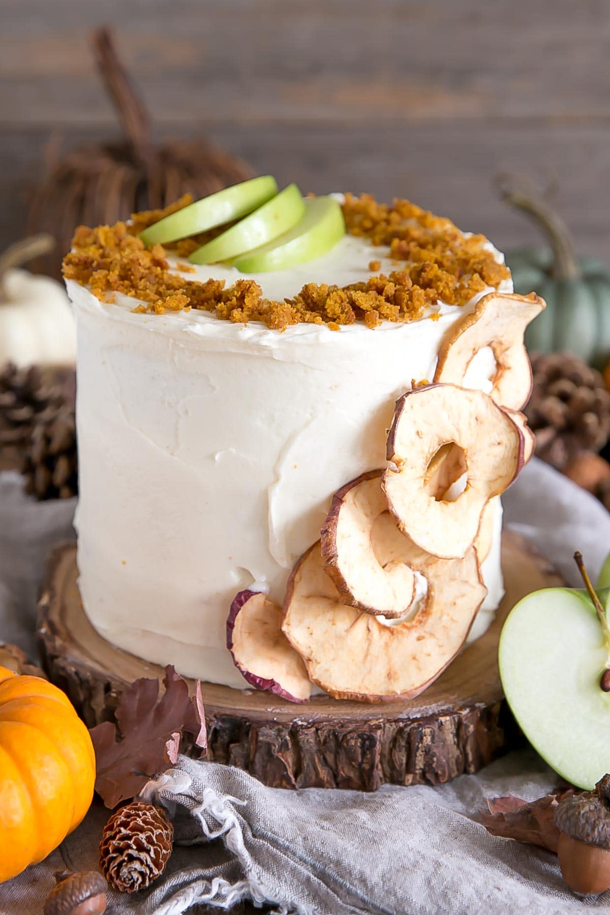 Pumpkin cake with apple pie filling frosted in a cream cheese frosting. Decorated with dried apple slices and pumpkin cake crumbs.