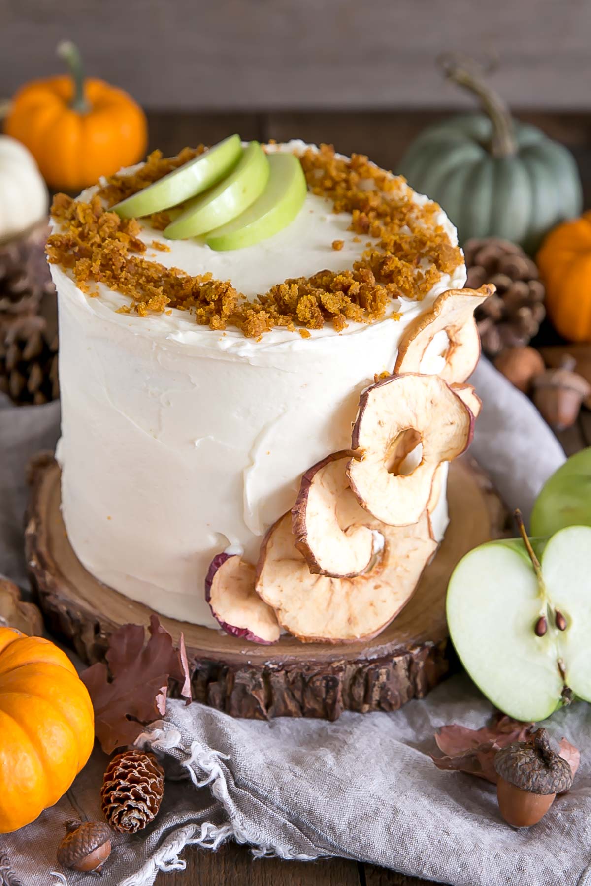 Pumpkin cake on a rustic wood cake stand with Fall decor around it.