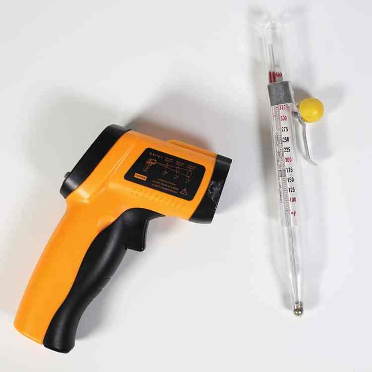 infrared thermometer on table next to a glass thermometer