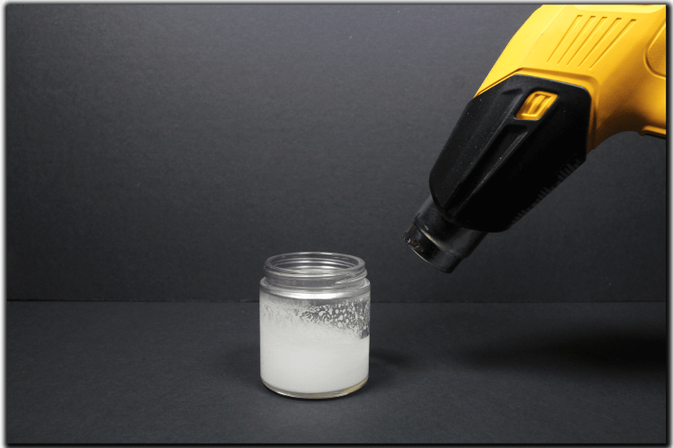 melt the side of the candle jar with a heat gun or hair dryer before scraping out the wax