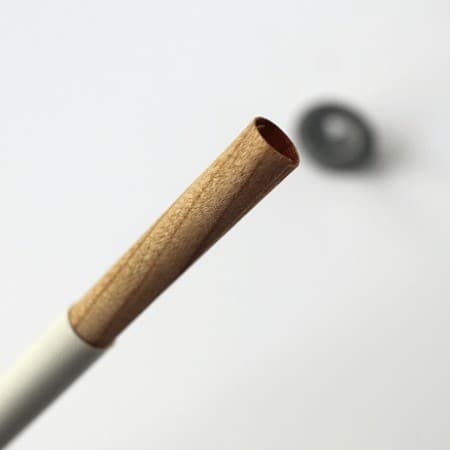 up close view of a spiral wick sticking out of its white holding tube