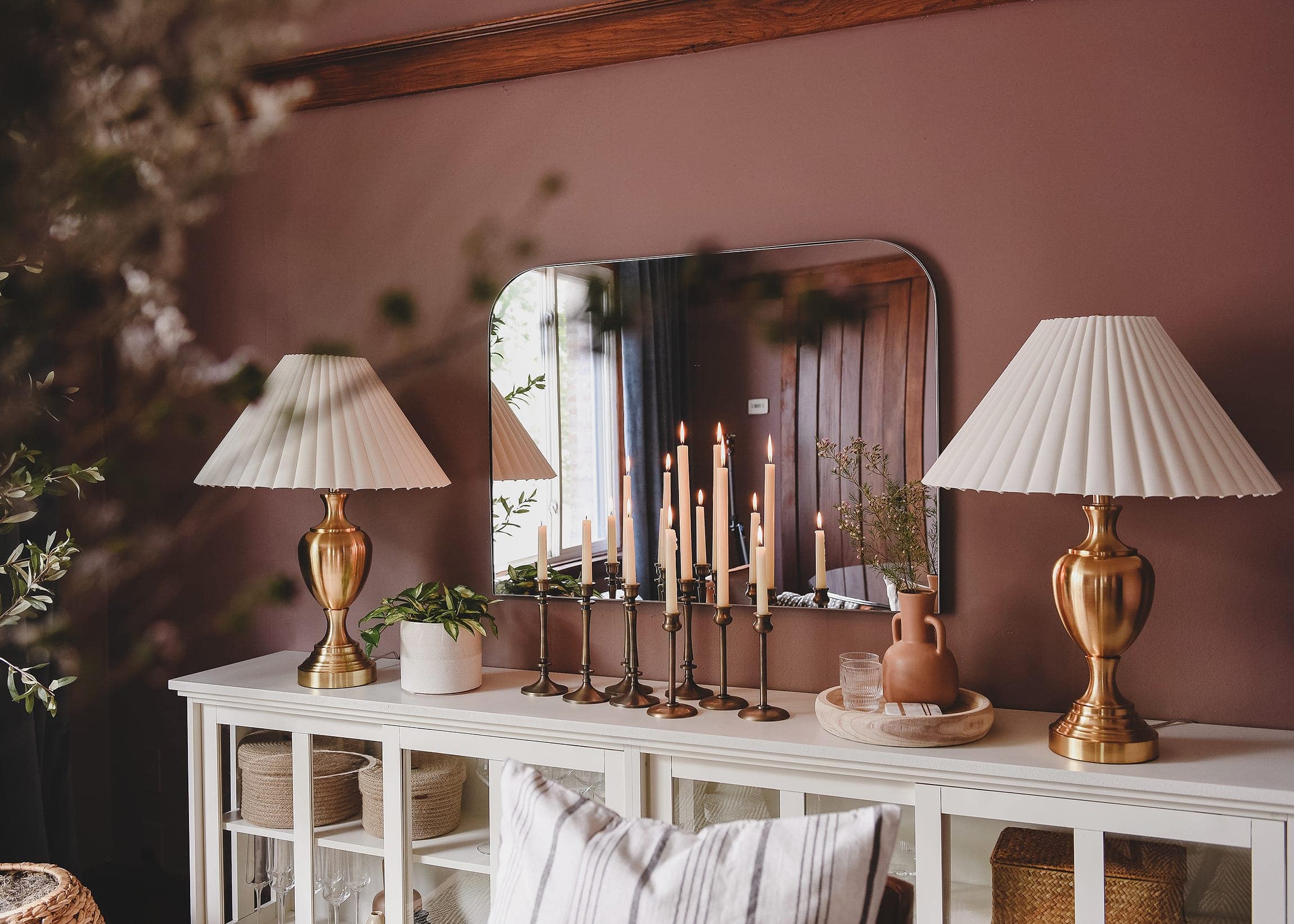 Sideboard with a mirror and two gold lamps