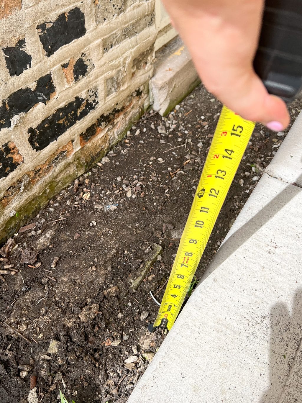 Using a tape measure when working on our pea gravel border