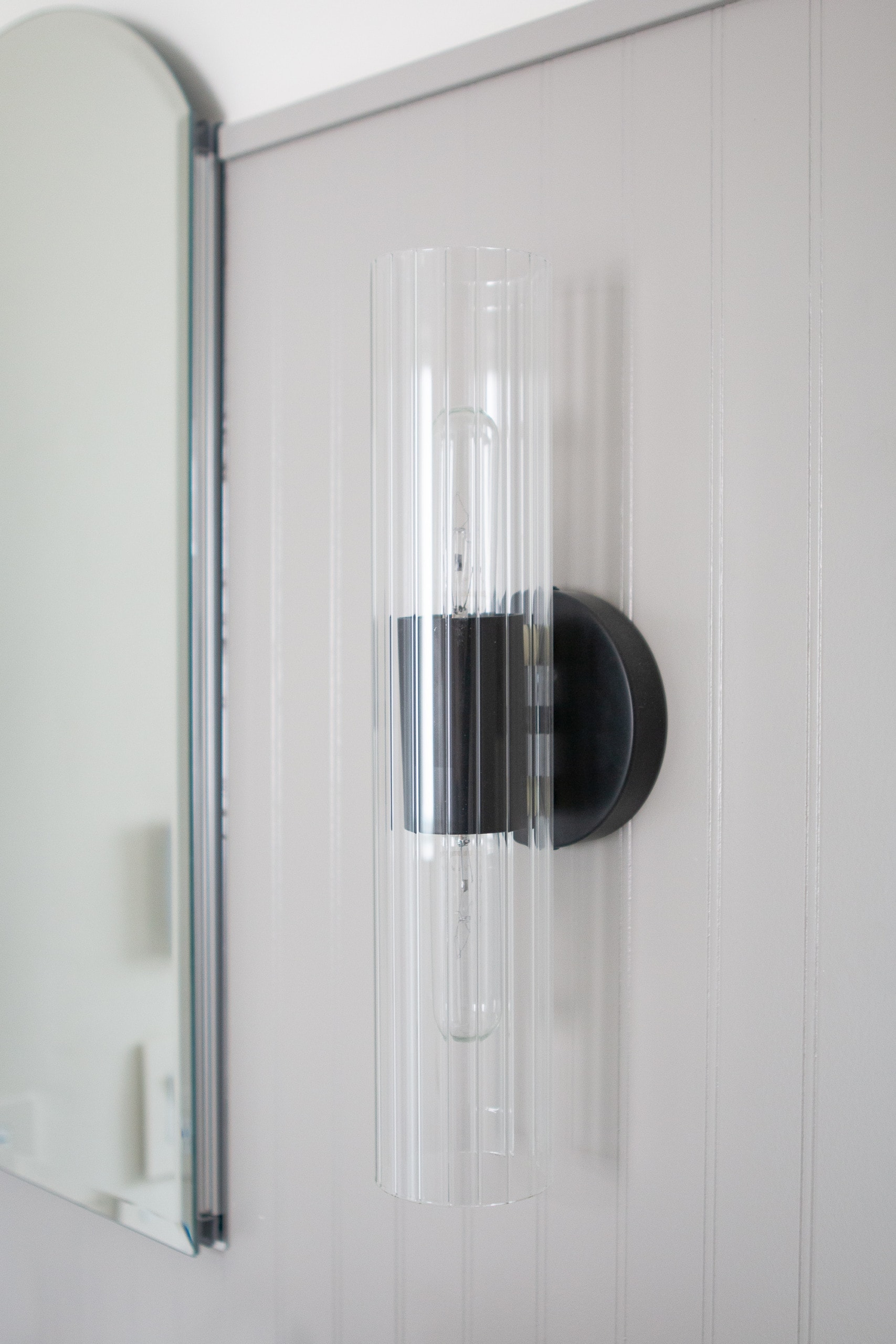 A black sconce for a bathroom