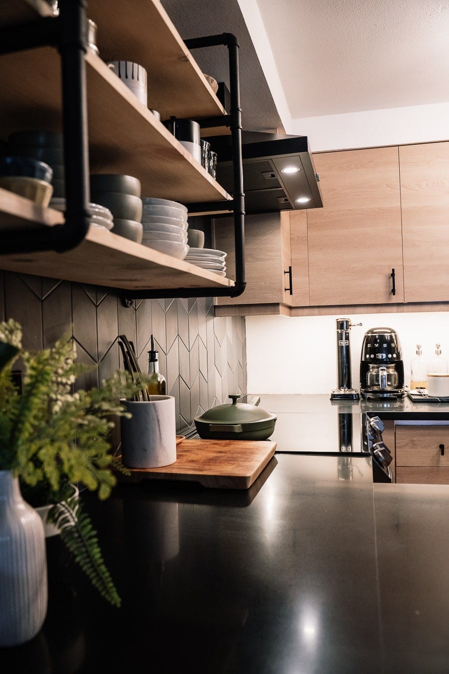 black kitchen counters with wood open shelve in this moody home tour