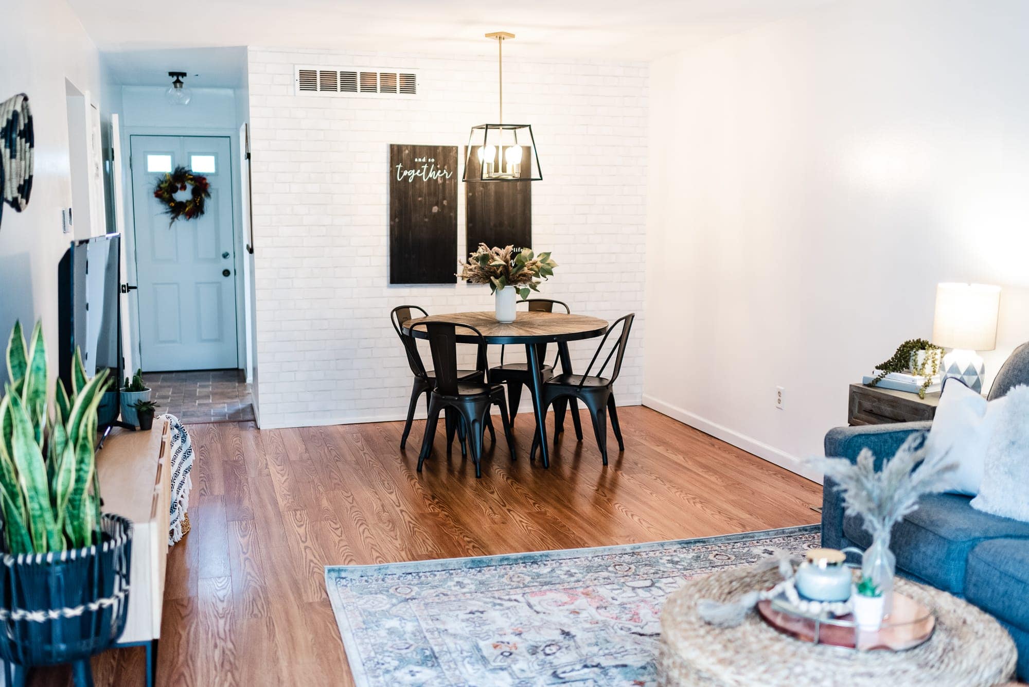 farmhouse condo with a white brick wallpaper and round dining table