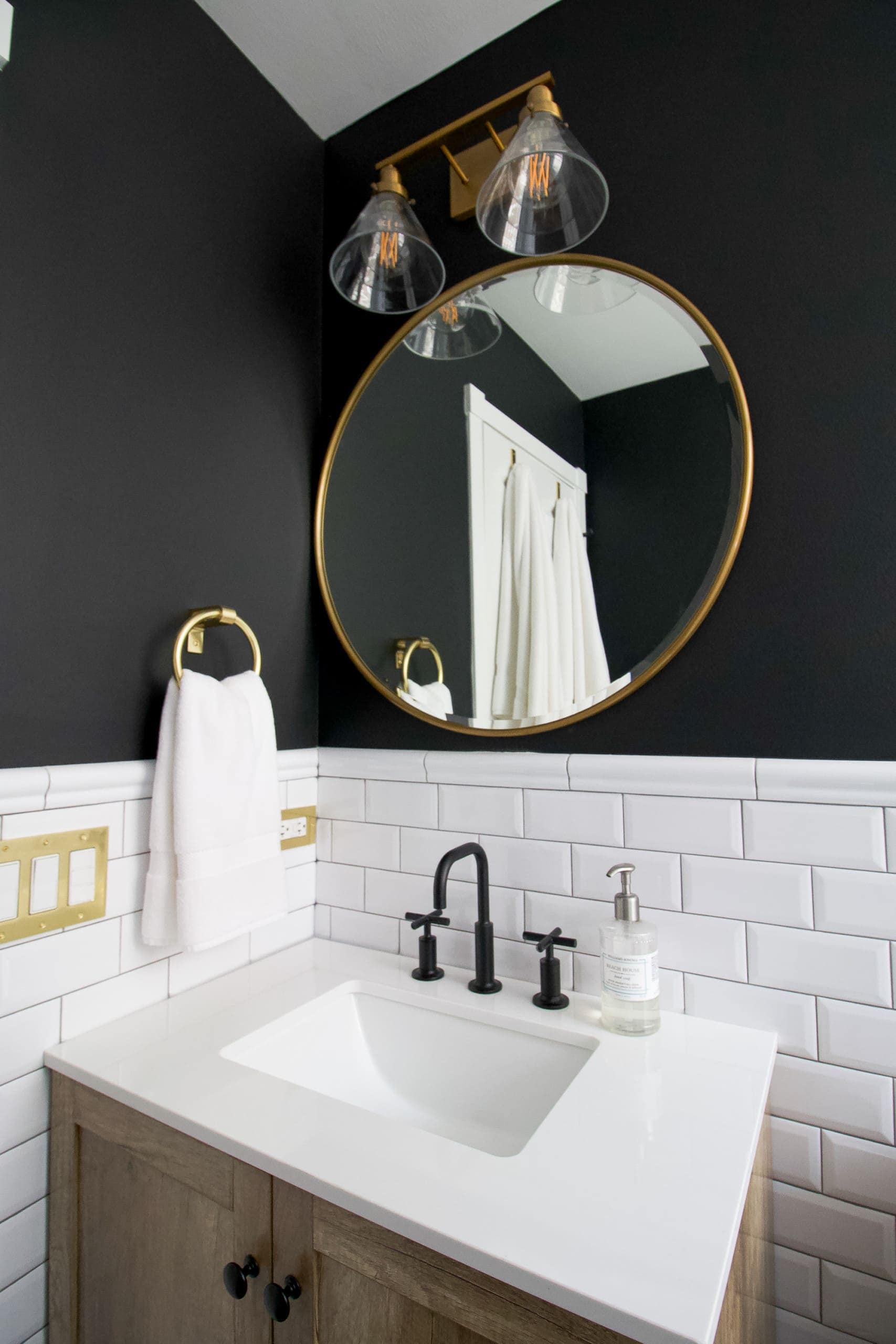 A bathroom vanity with gold mirror