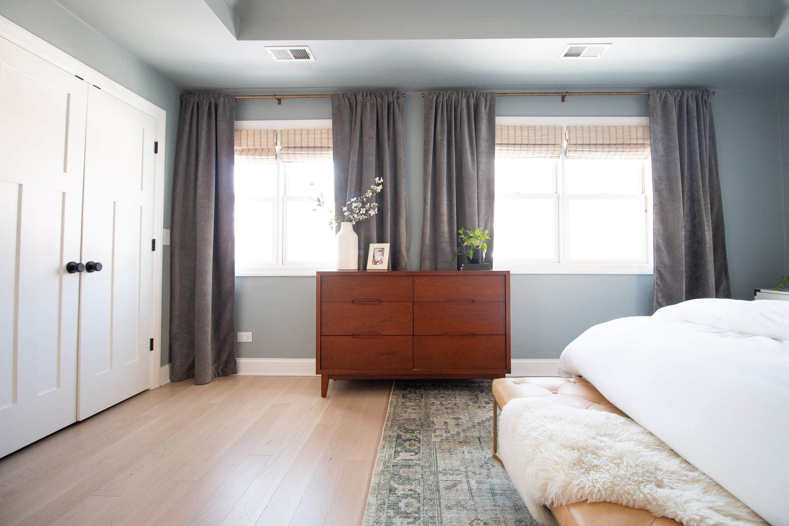 A blue gray bedroom with gray velvet curtains