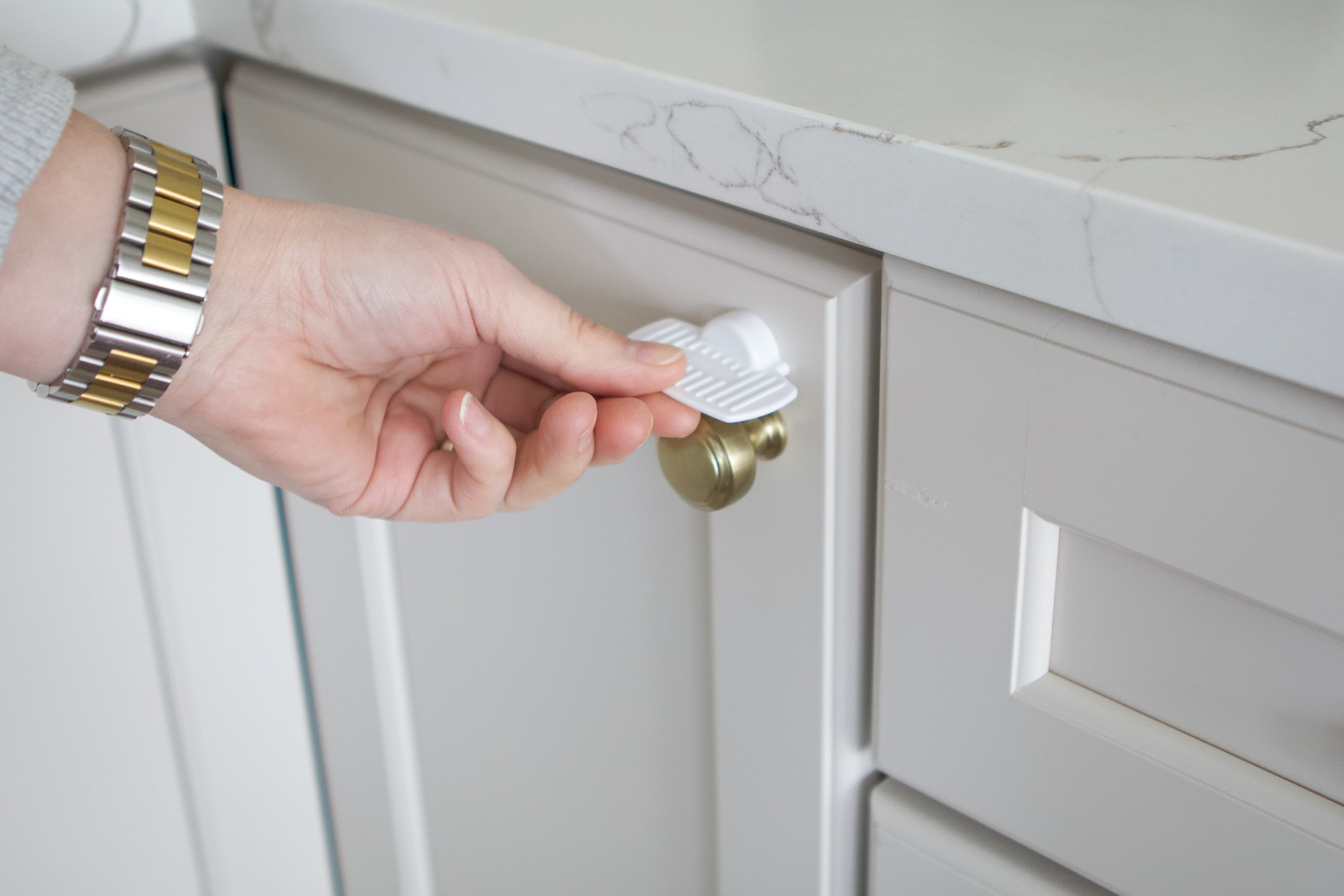 Magnet to open and close a kitchen cabinet to babyproof your home