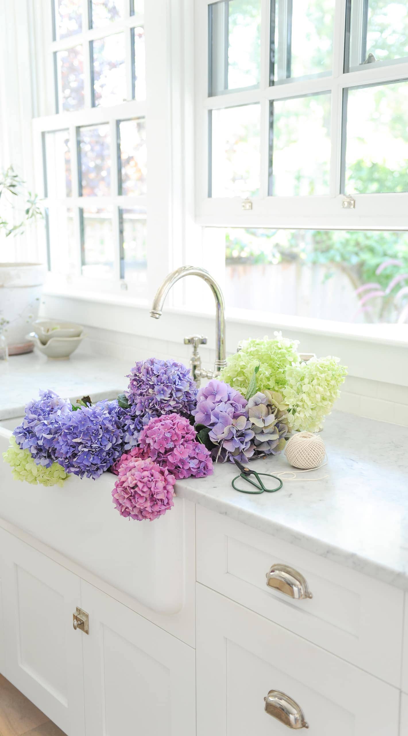 Purple hydrangeas in a white sink