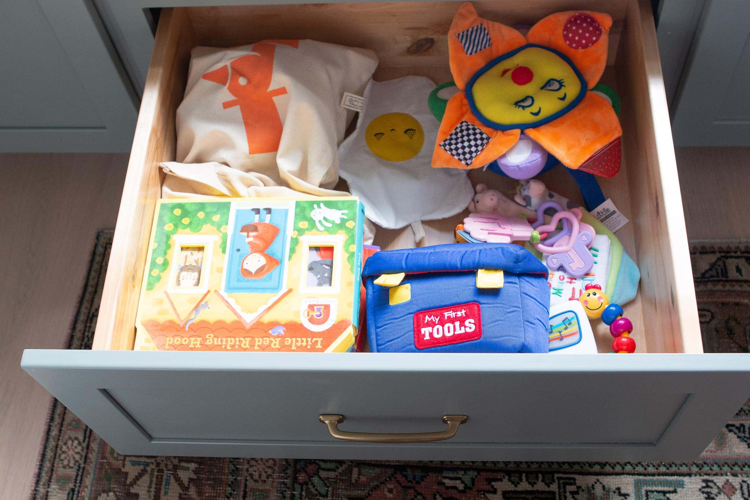 Adding toys to a drawer in the nursery