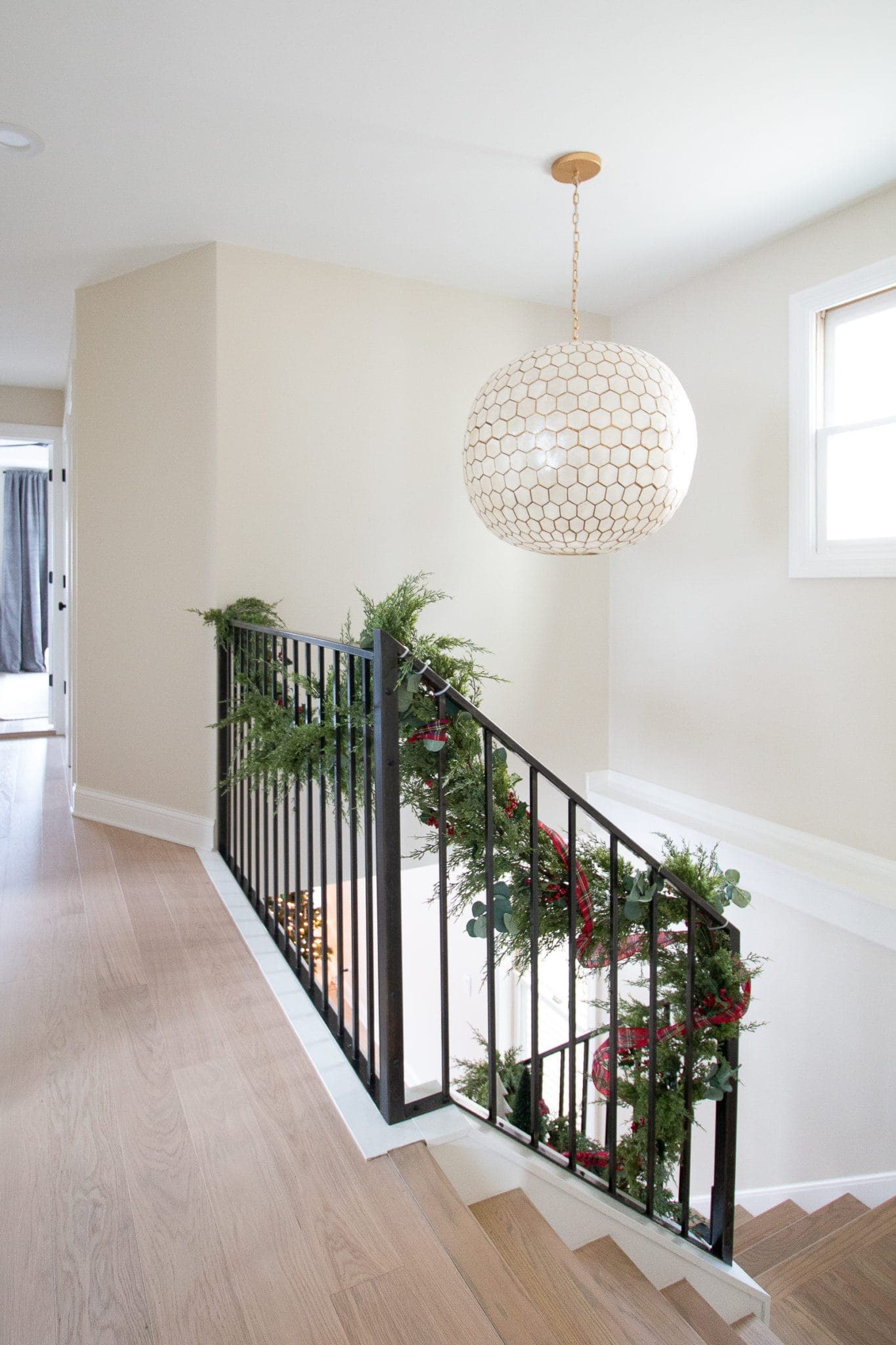 Adding garland to our staircase banister for Christmas