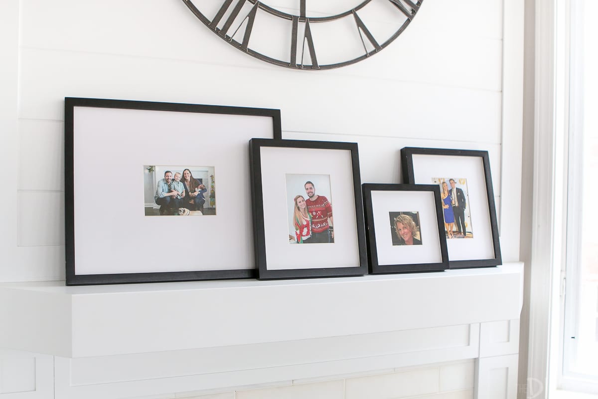 Framed photos on a fireplace mantle