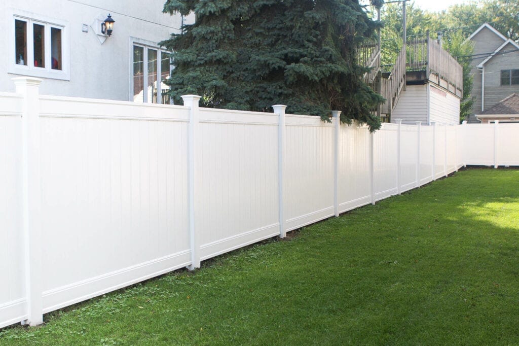 A long white vinyl fence in the yard