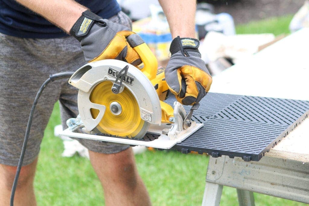 using a circular saw to cut garage floor tiles