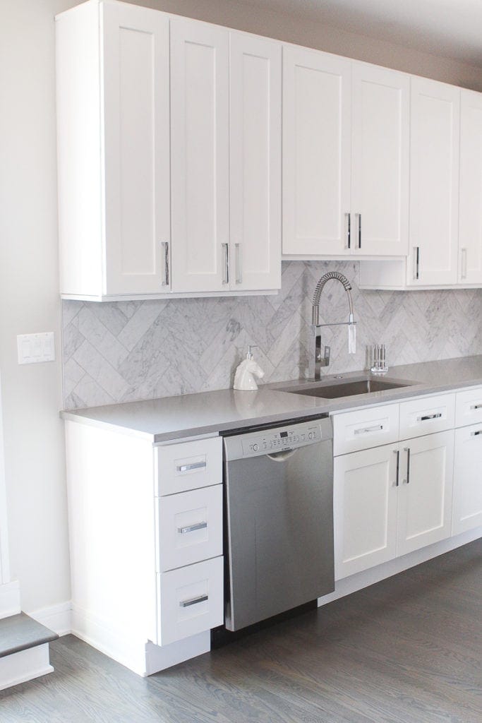 White kitchen cabinets and marble backsplash