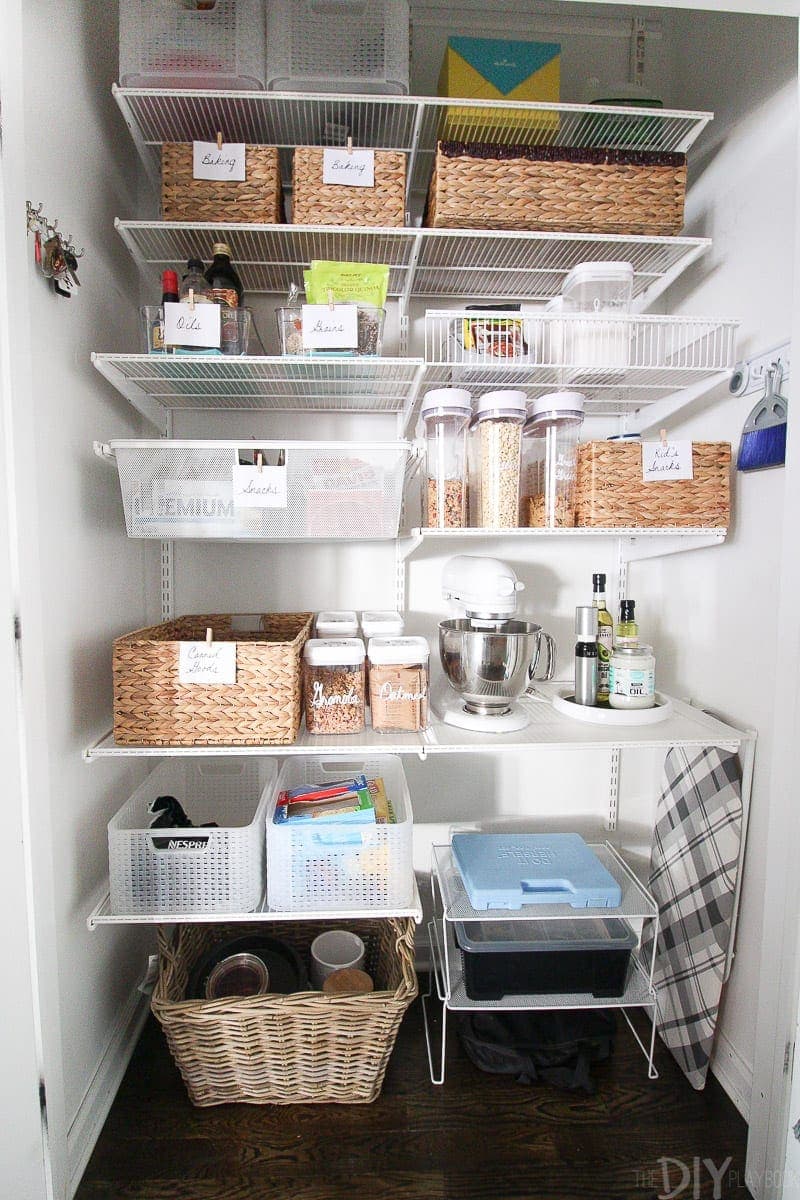 An organized pantry with labels and wicker baskets