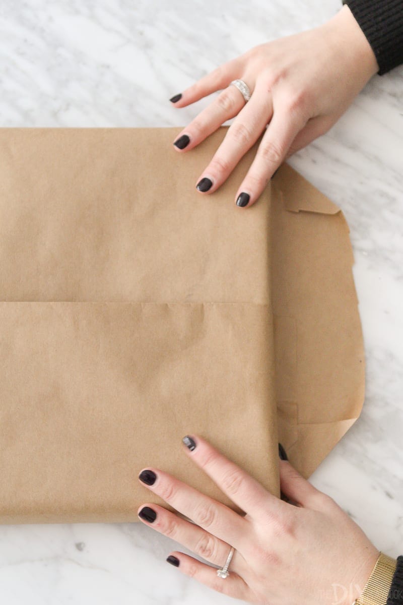 Folding edges of wrapping paper to wrap a gift