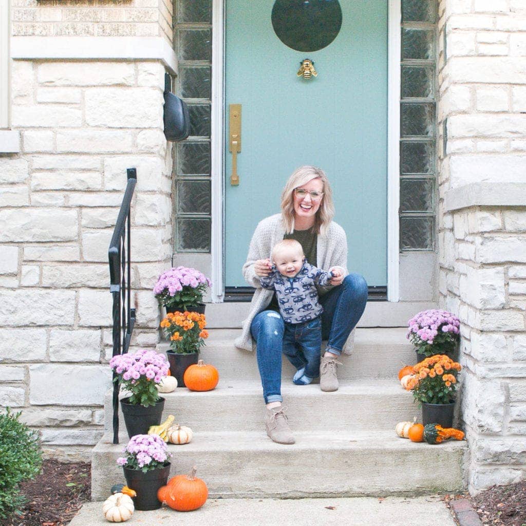 Bridget and Ben on the front porch with pumpkins and mums for fall 