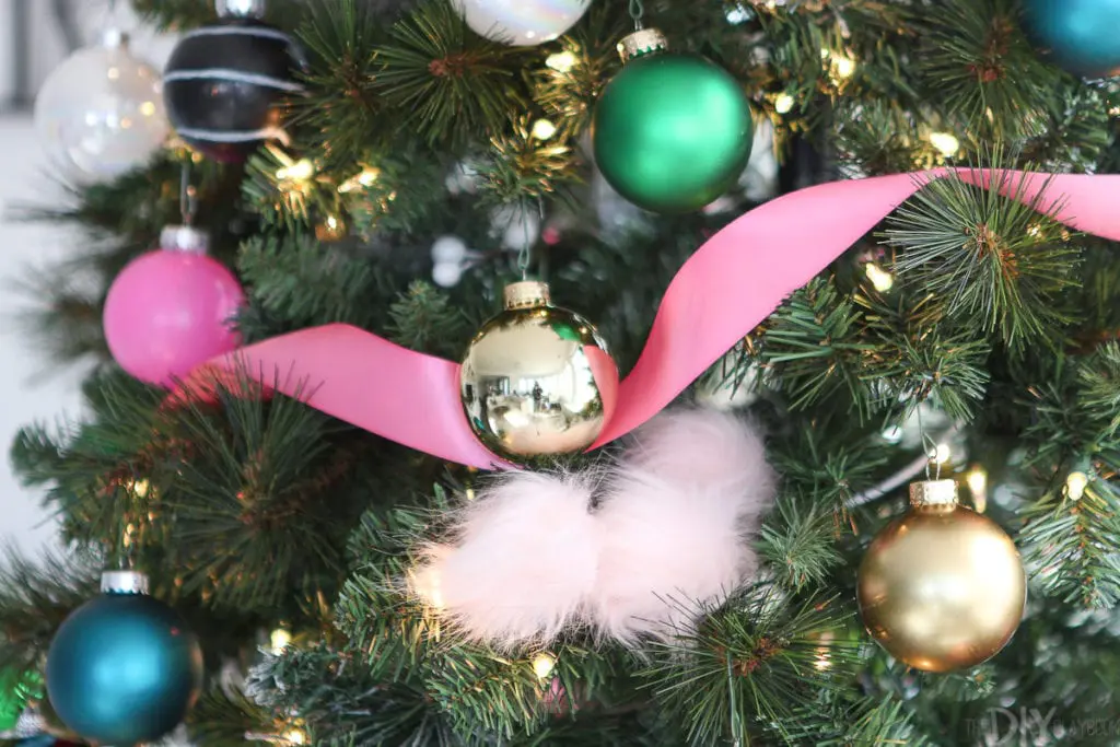 Pink ribbon and gold ornaments on this colorful Christmas tree
