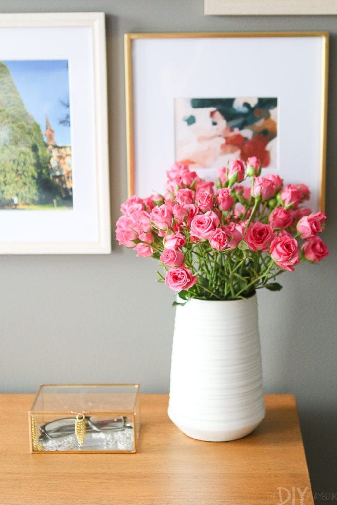 A white Homegoods vase with pink flowers