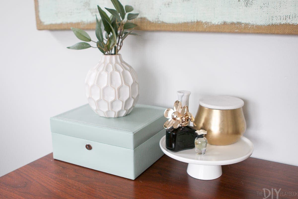 Home decor accessories on the top of a dresser in the bedroom. 