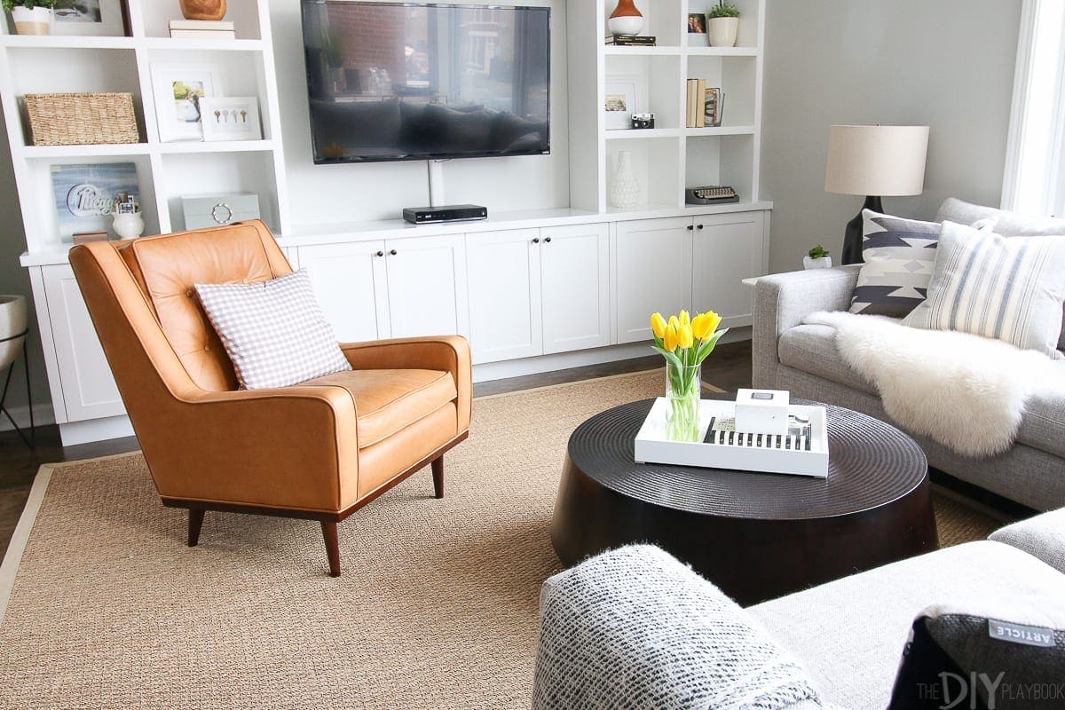 A black round coffee table in a family room space. 