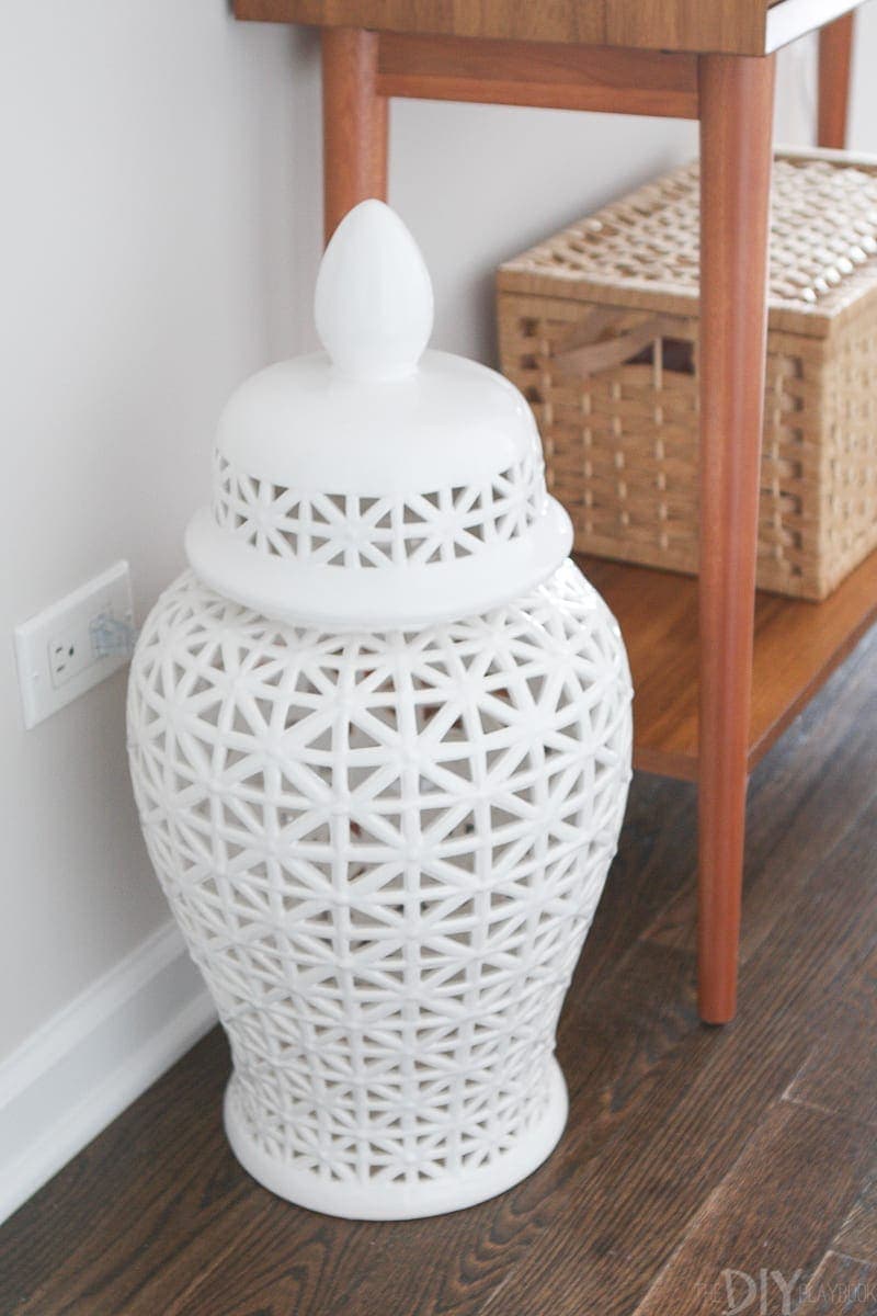 This large white vase covers an outlet in this functional entryway