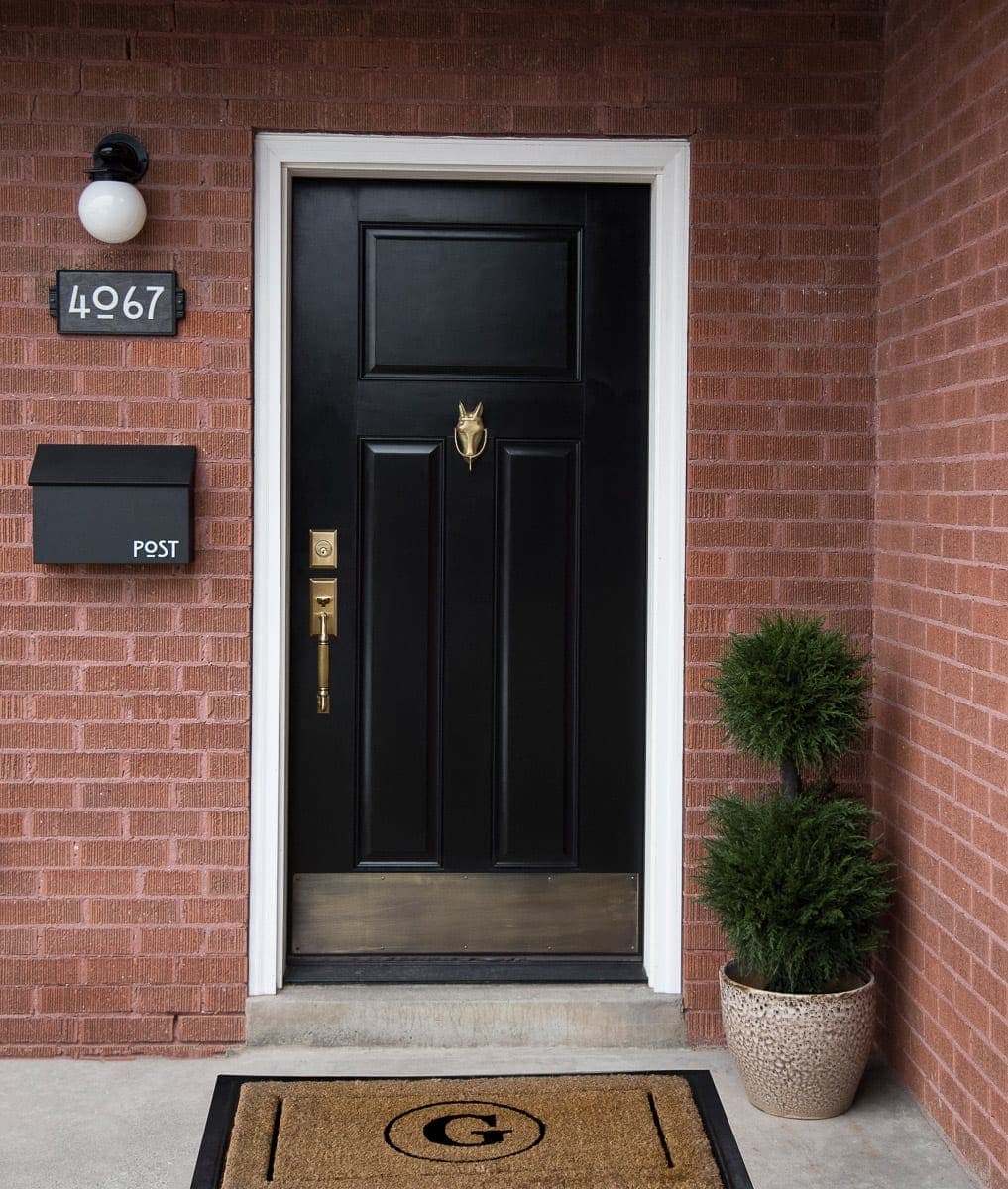 A black front door with red brick. 