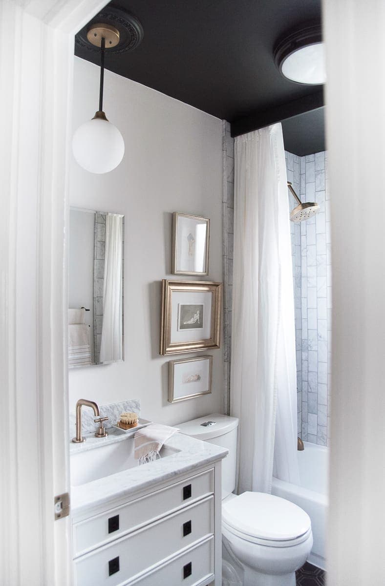 A white, black, and marble bathroom from the blog Room for Tuesday. 