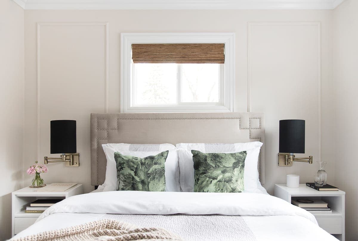 White bedding in this guest room with palm print pillows. 