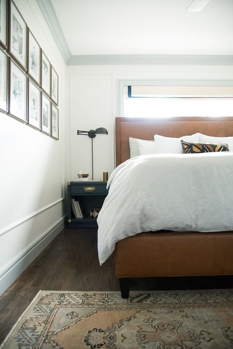 A master bedroom with a leather headboard. 