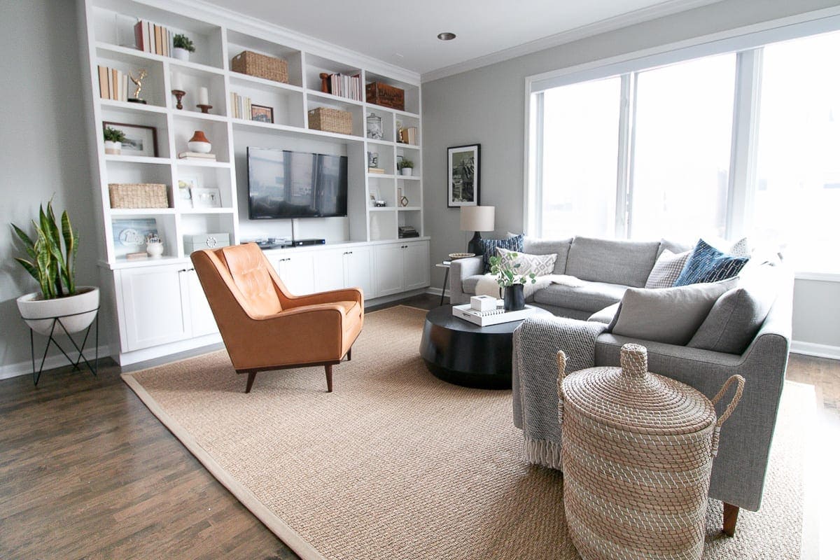 A large living room with a gray sectional and built-in entertainment center. 