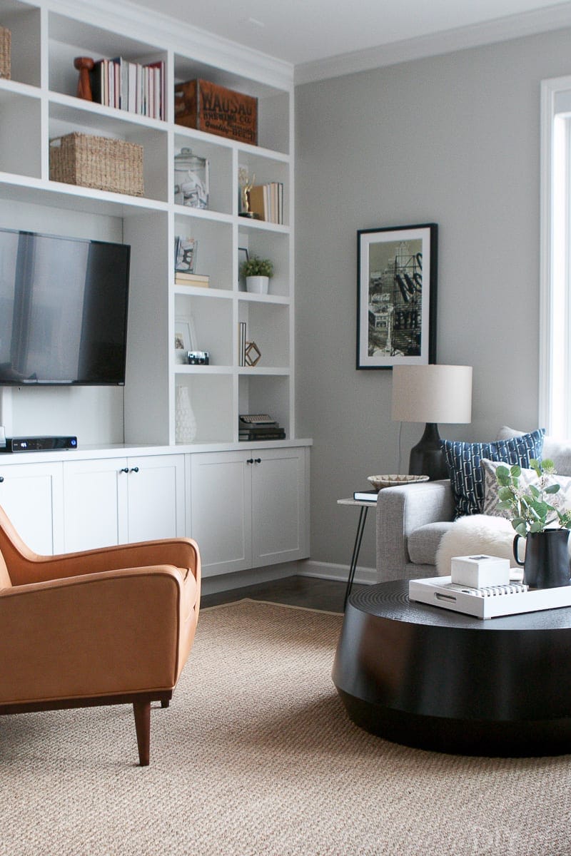 A round coffee table works well with the legs of the chair and couch in this family room. 