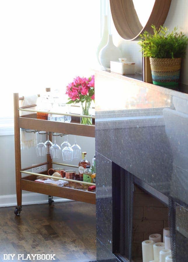 A modern bar cart in the corner of a family room to hold all of the cocktail necessities. 