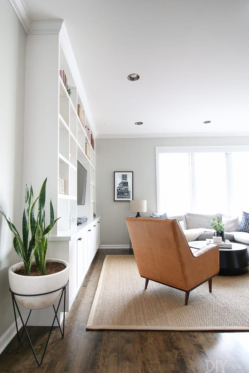 This living room space works well with a leather chair opposite the gray sectional. 