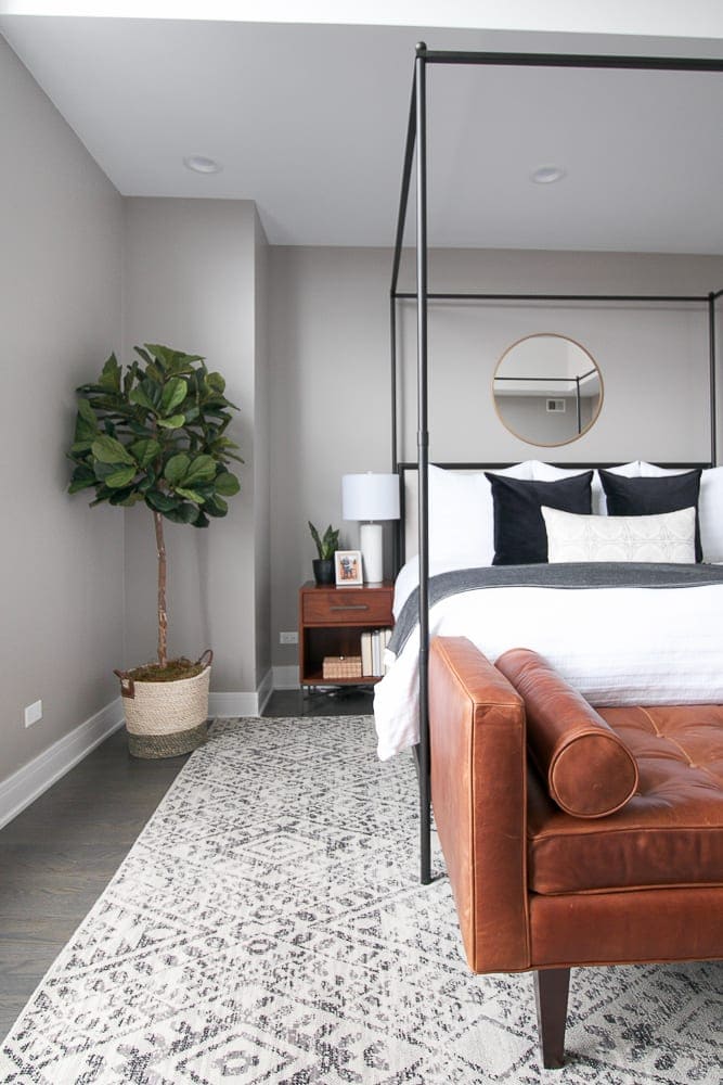 Gray and white bedroom with leather bench from Rejuvenation. 