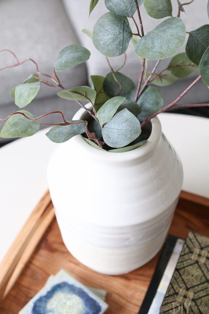 Faux greenery on a coffee table adds some life to a neutral living room 