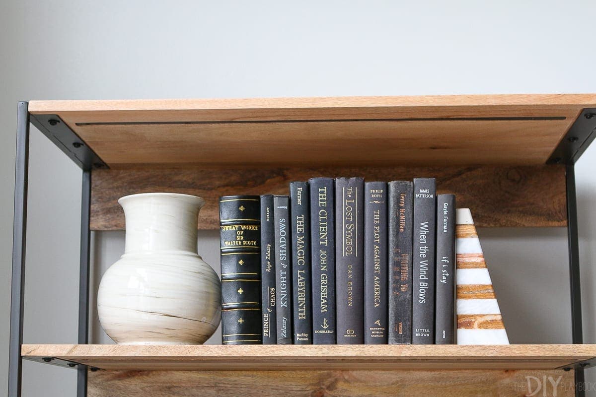 I love to sandwich hardcovered books with pretty vases and sculptural objects on a shelf. 