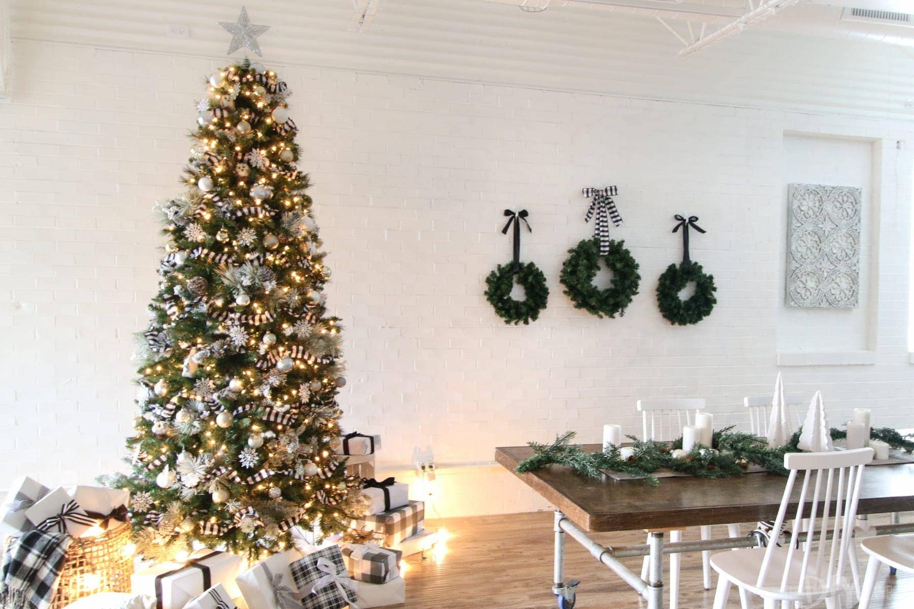 This Christmas tree decorated in black and white looks so cute next to the three wreaths: simple, elegant holiday decorating.