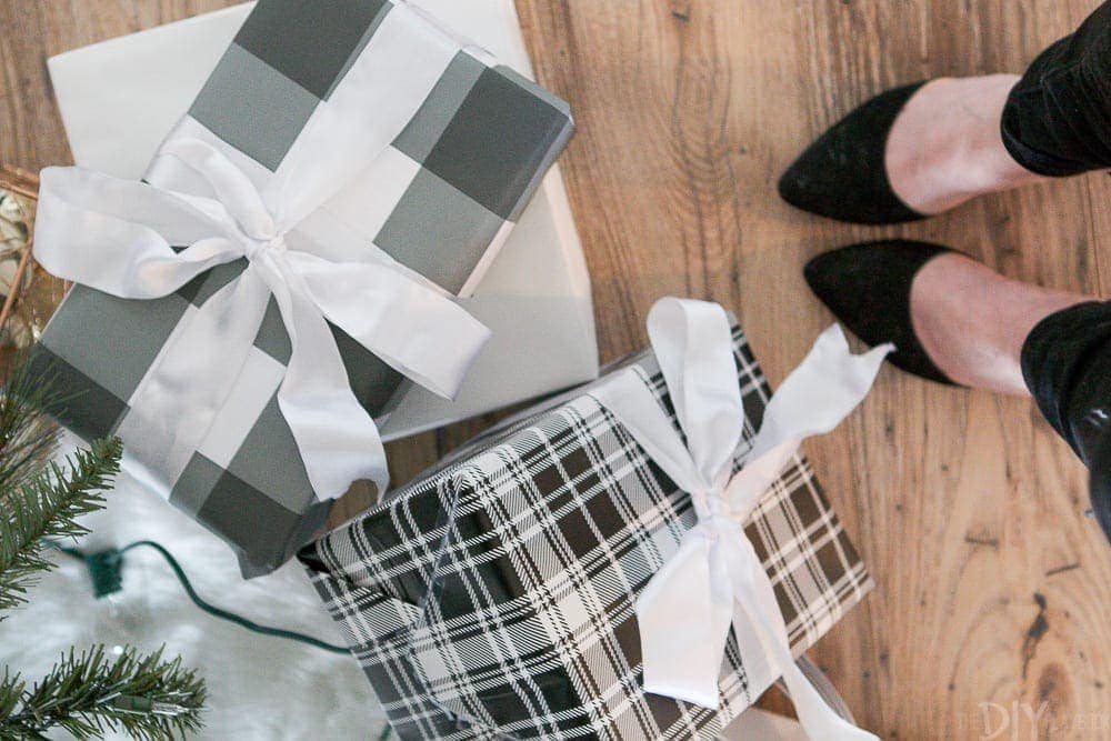 Wrapped presents under the tree with white bows and gray plaid wrapping paper. 