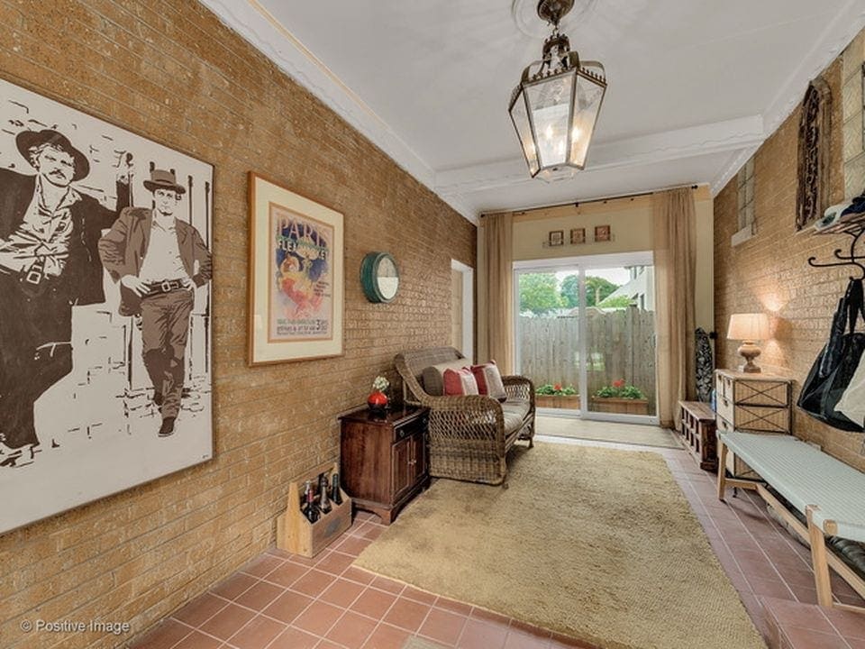 Here is the gold brick hallway of the mudroom with art and a door leading out to the patio. 