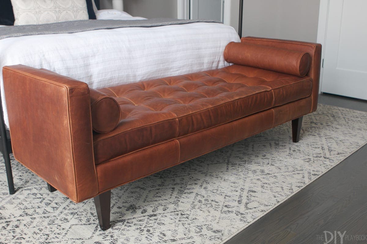 Stylish and modern brown leather bench at the foot of the master bed. 